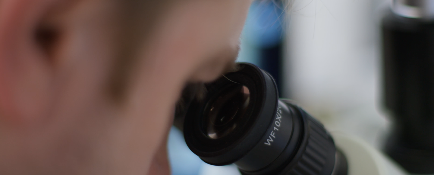 Eye looking through microscope